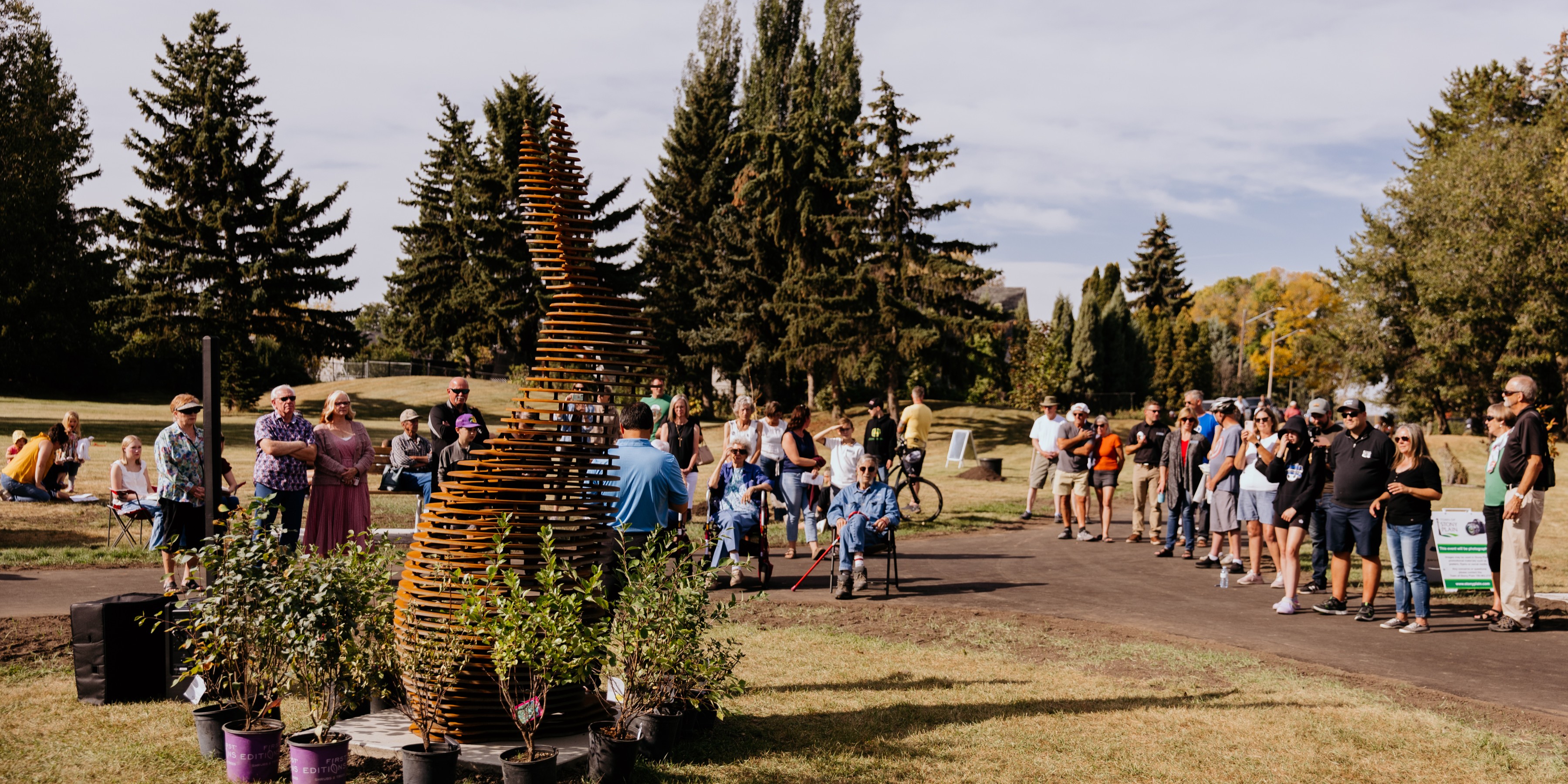 image of people standing in a park with a large rabbit sculpture